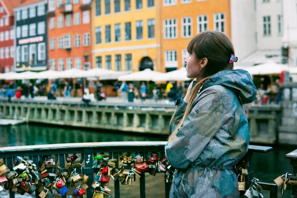 Woman Standing Near Orange, Yellow, and White Buildings