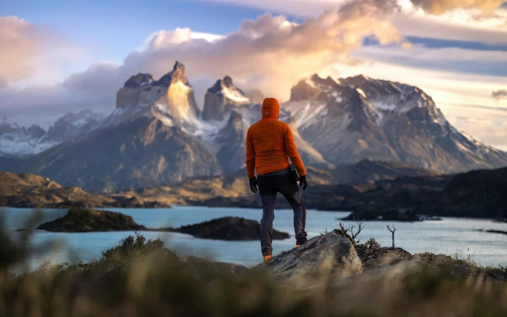 a hiker at sunrise in torres del paine chile