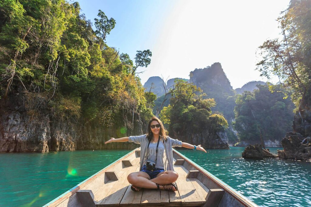 a woman sitting on a boat spreading her arms