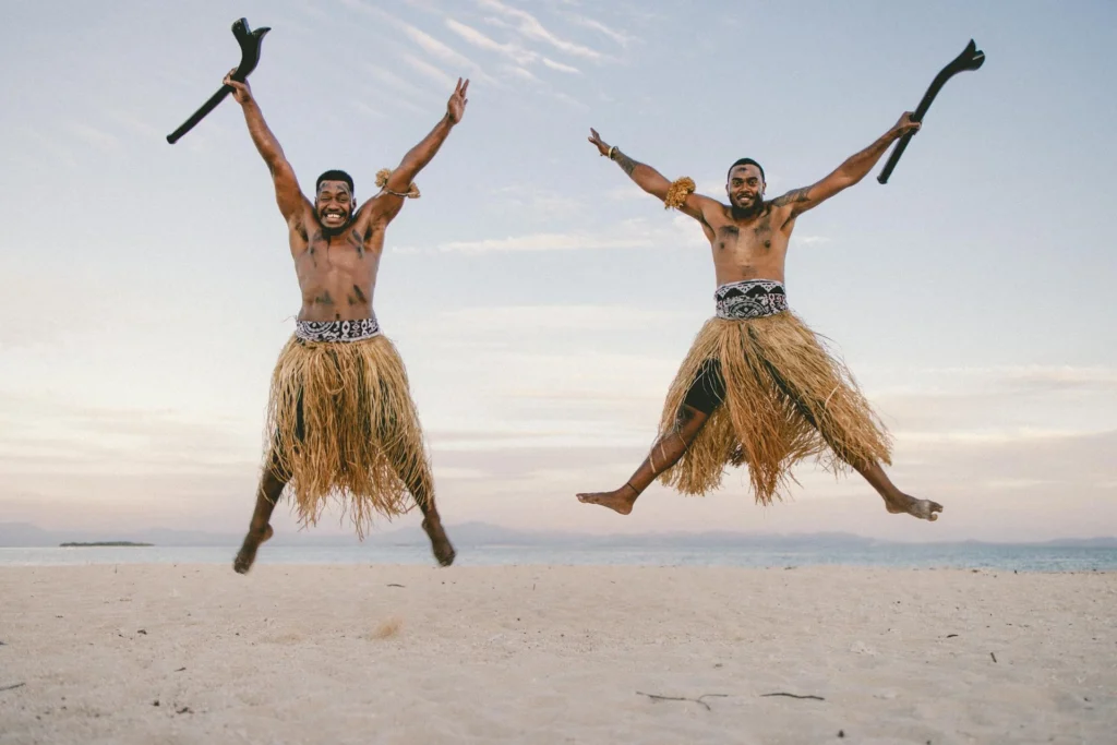 two men jumping happily on a beach