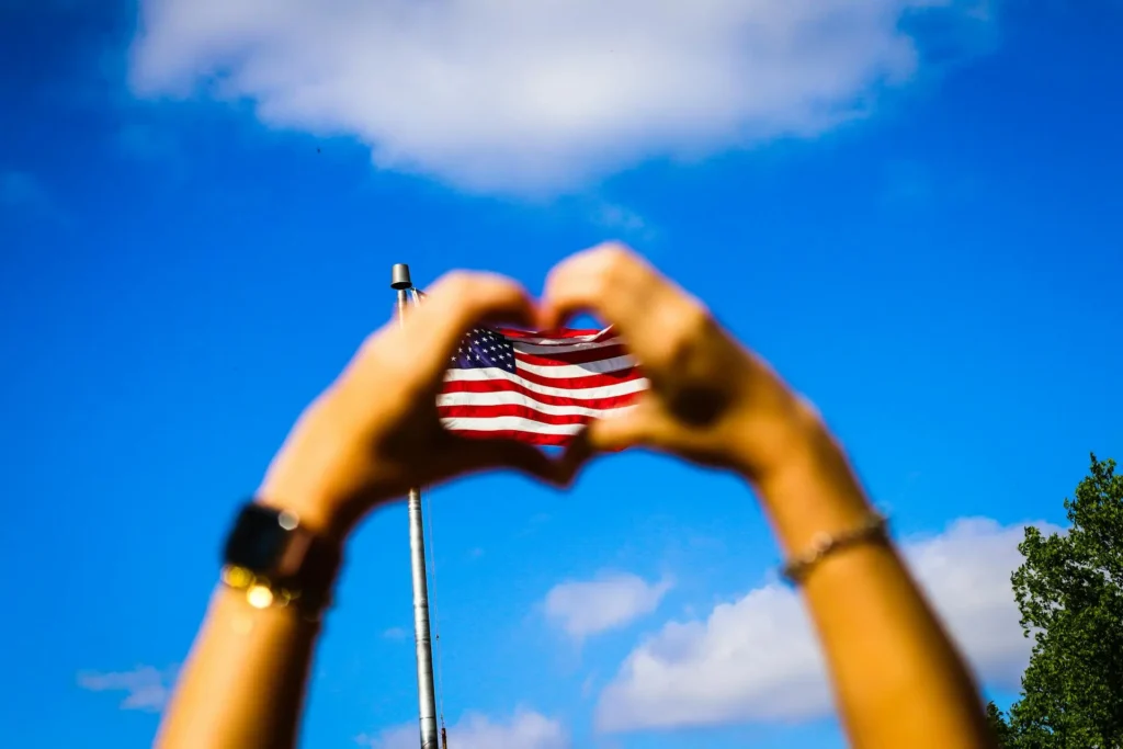 Human Hands forming a love sign over Us Flag